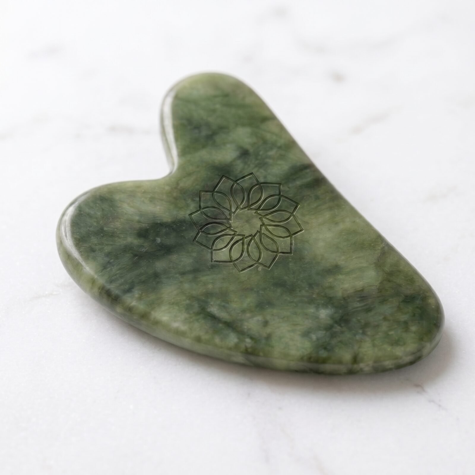 Gua sha en jade vert naturel, gravé de la rosace Radieuses.