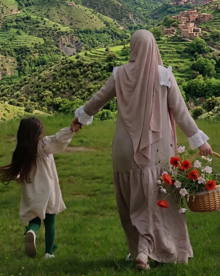 Une mère et sa fille marchent main dans la main vers les villages de l’Atlas marocain